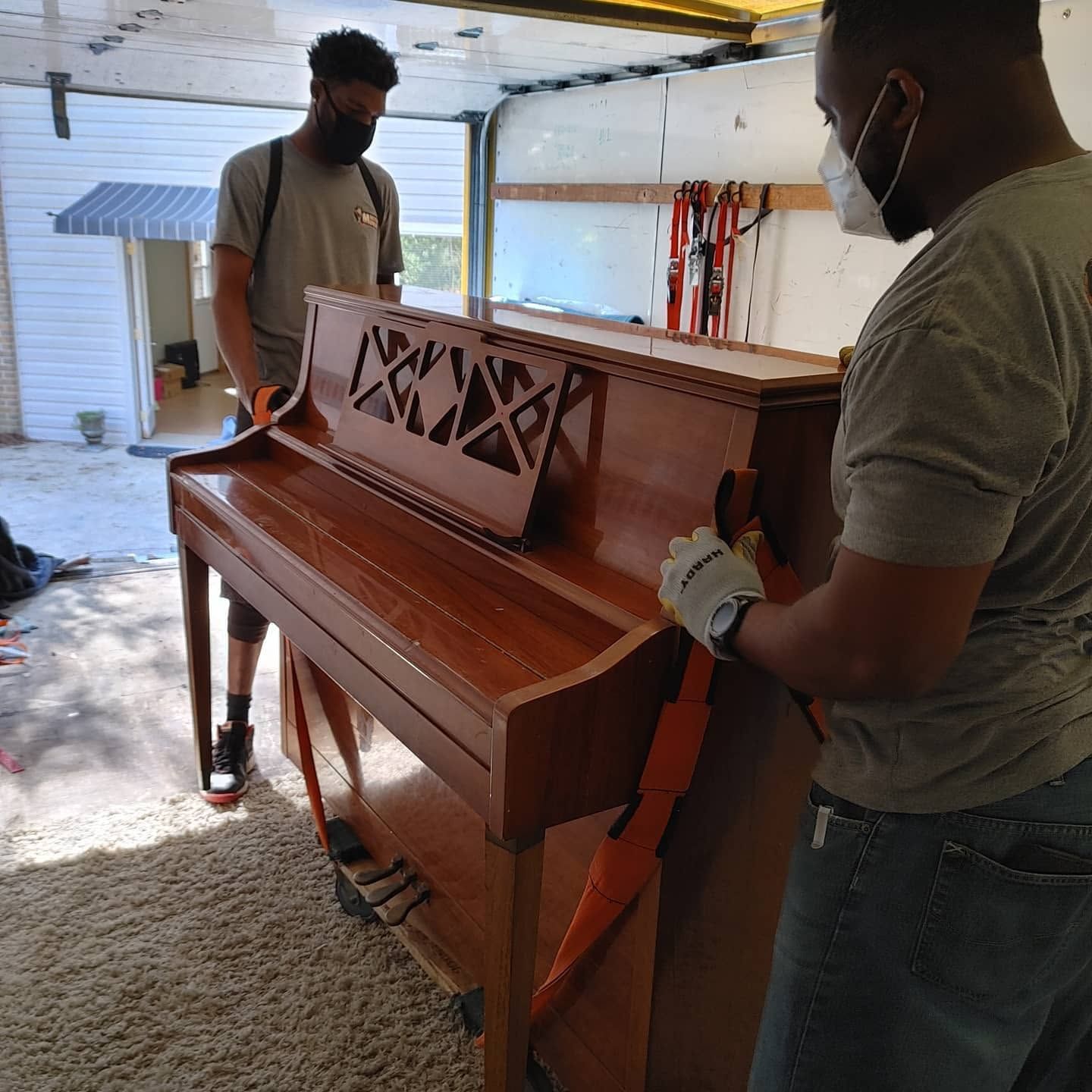 Master Movers of Tallahassee crew strapping an upright piano onto a dolly during a Tallahassee piano